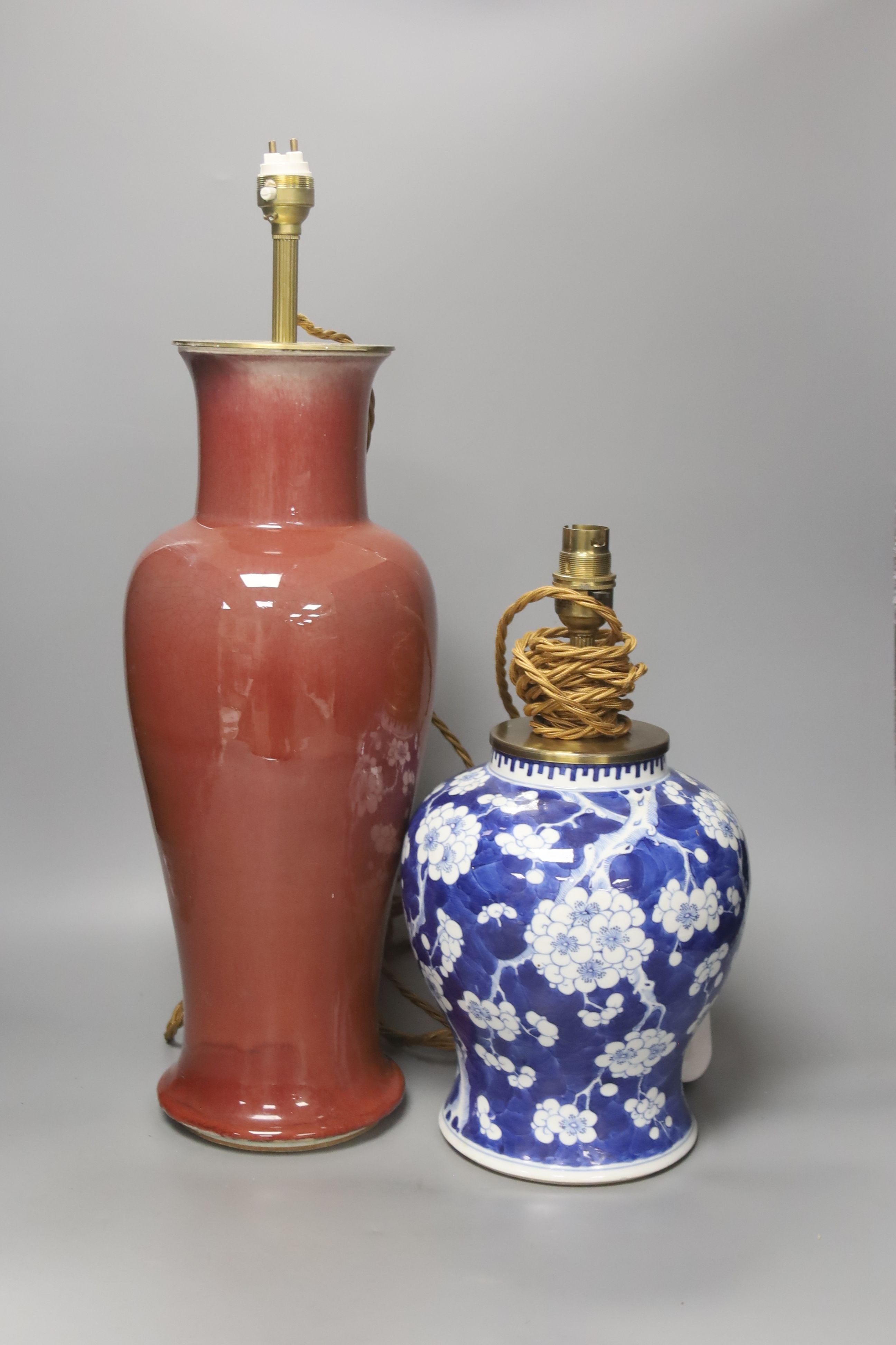 A large Chinese sang de boeuf lamp base and a similar blue and white prunus lamp base, both Qing dynasty, 41 and 21 cm high excluding fittings